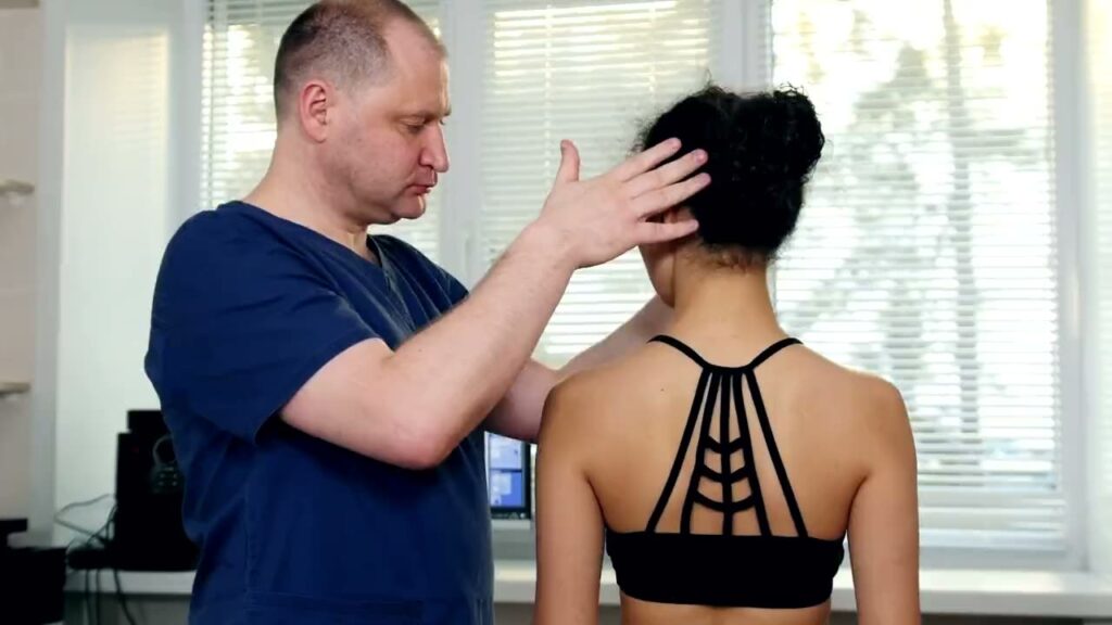 A Physiotherapist assesses a patient in a bright clinic room